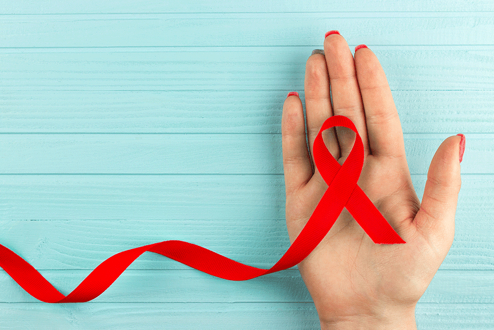 HIV-Awareness_12.22 HIV and AIDS awareness ribbon on a hand.