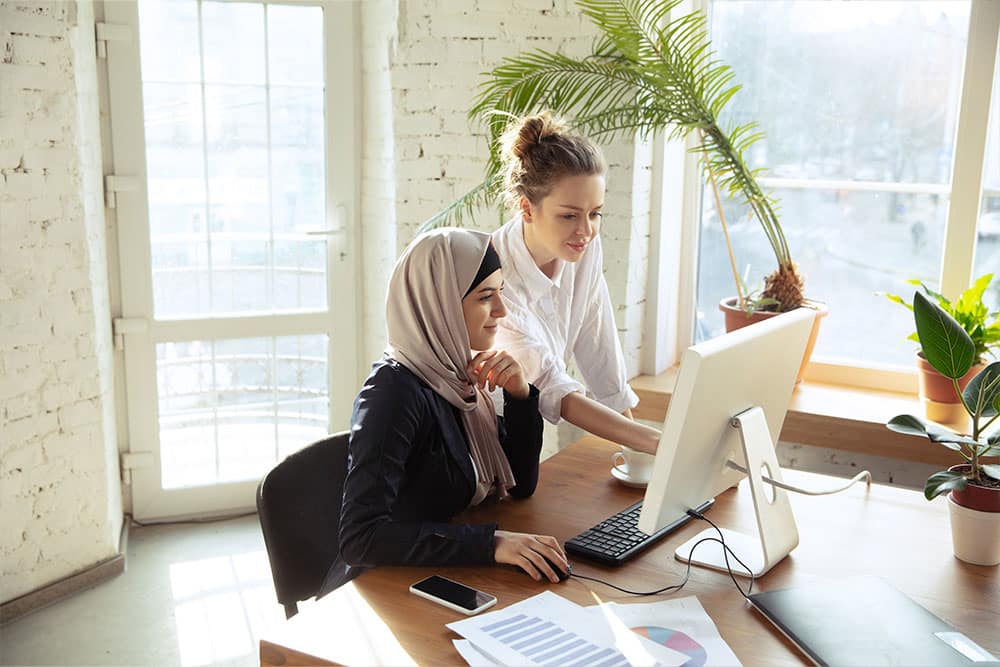 Two females working at desk.