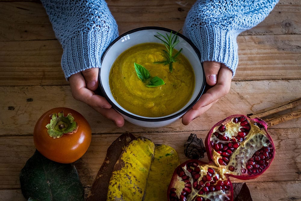Female holding bowl of soup.