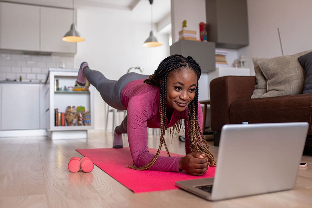 Person using online fitness video to boost wellbeing